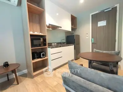 Modern compact kitchen with sleek appliances and cozy seating area.