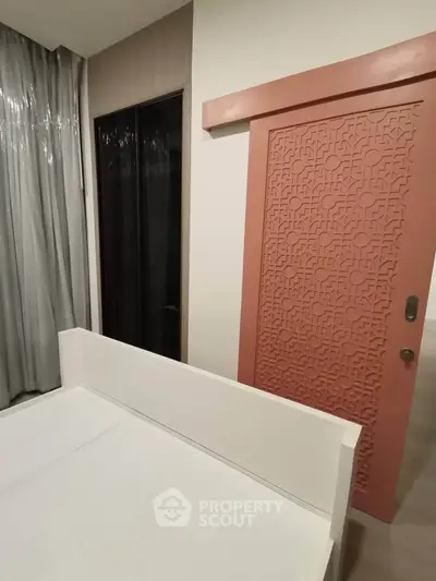 Modern bedroom with stylish pink sliding door and elegant curtains