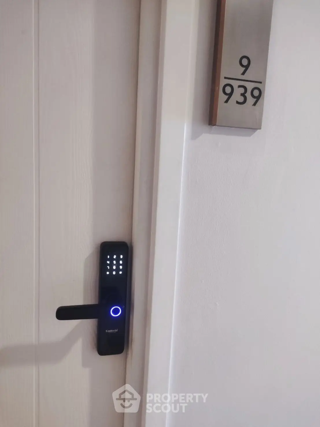 Modern apartment door with electronic lock and room number 939, showcasing security and style.