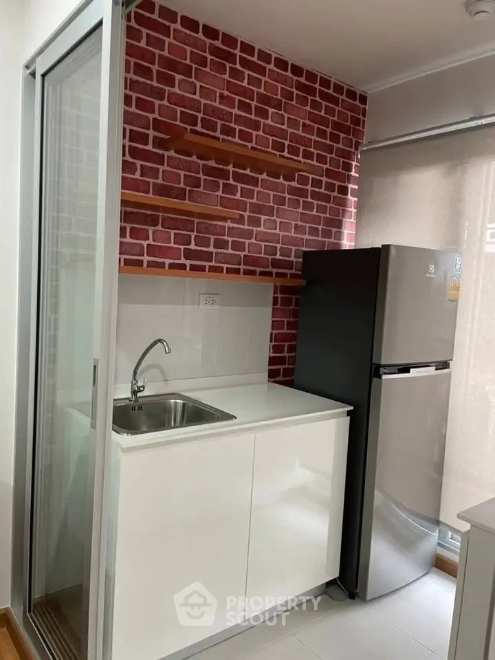 Modern compact kitchen with brick accent wall and sleek appliances