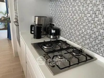 Modern kitchen with sleek gas stove and stylish backsplash tiles