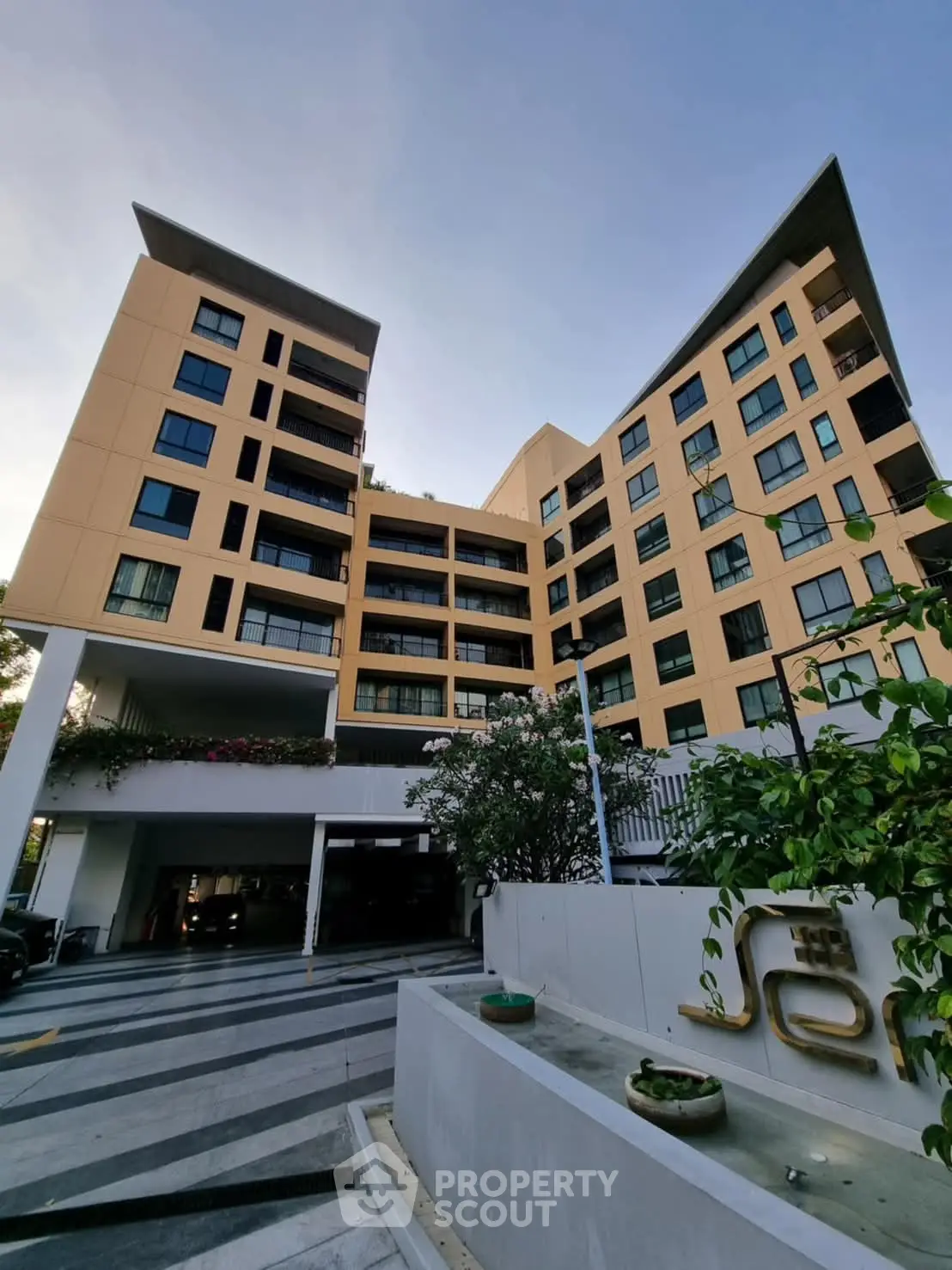 Modern apartment building with unique architecture and lush greenery