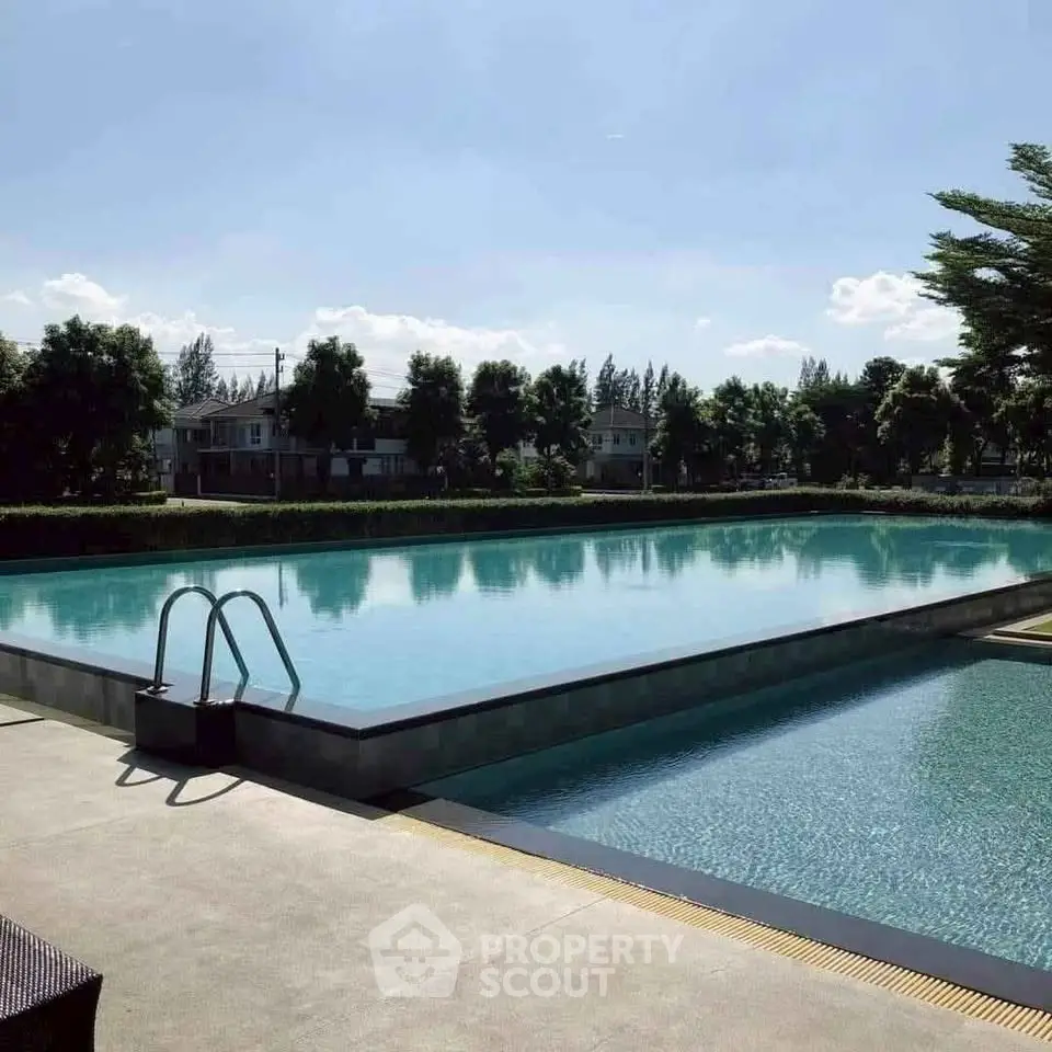 Luxurious outdoor pool with serene surroundings and clear blue sky.