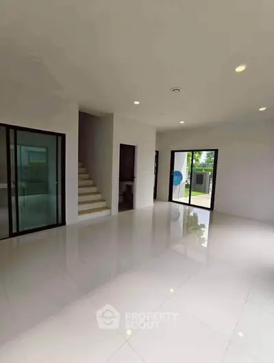 Spacious modern living room with large windows and sleek tile flooring