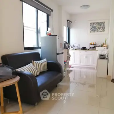 Charming compact living room with modern kitchenette and natural light