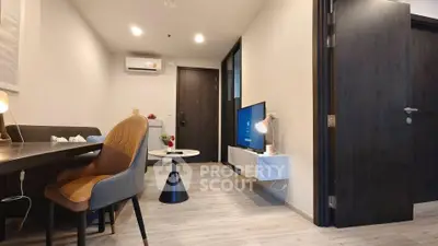 Modern living room with sleek furniture and wall-mounted TV in stylish apartment.