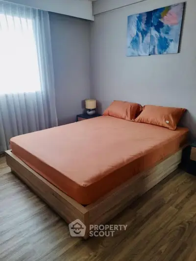 Cozy bedroom with modern decor and natural light, featuring a comfortable bed and stylish artwork.