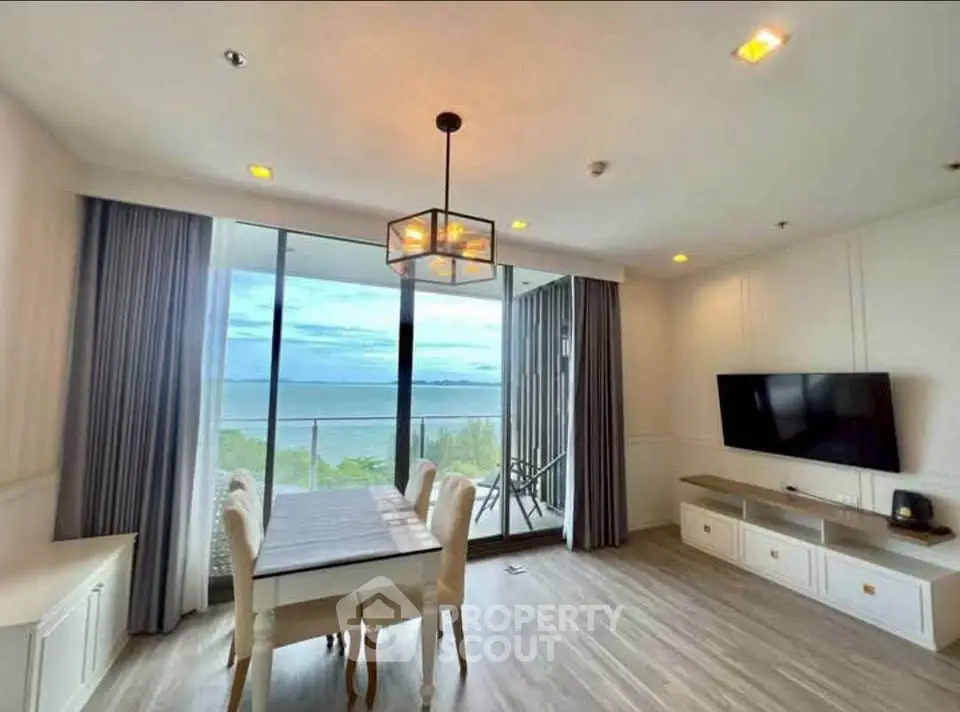 Stunning living room with ocean view, modern decor, and elegant dining area.