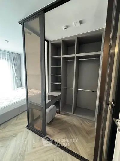 Modern bedroom with walk-in closet and elegant glass sliding doors