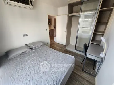Cozy bedroom with modern furnishings, featuring a comfortable bed, built-in wardrobe, and study desk.