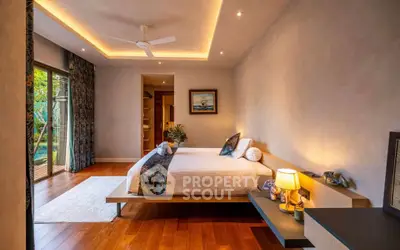 Luxurious bedroom with modern decor and garden view, featuring elegant lighting and wooden flooring.