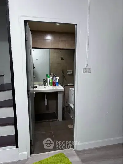 Compact bathroom with modern fixtures and neutral tiles, perfect for efficient space utilization.