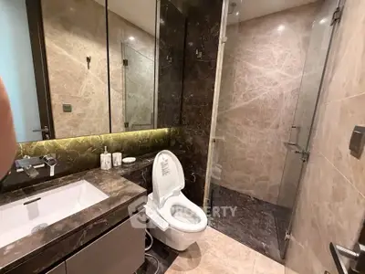 Luxurious modern bathroom with marble tiles and glass shower enclosure