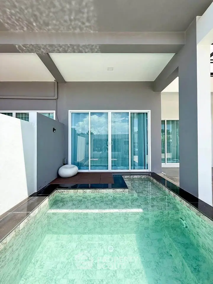 Luxurious private pool area with modern design and large sliding glass doors.