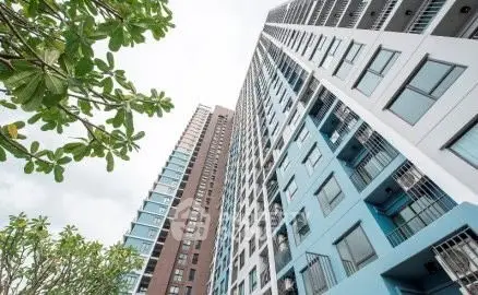 Modern high-rise apartment building with sleek architecture and lush greenery.