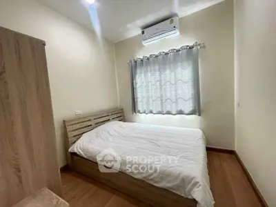 Cozy bedroom with wooden flooring and air conditioning