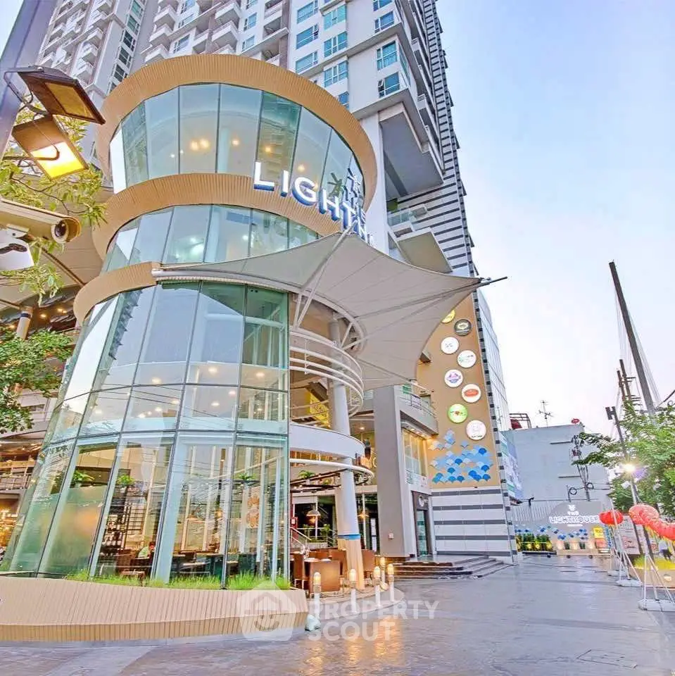 Modern high-rise building with glass facade and stylish entrance in urban setting.