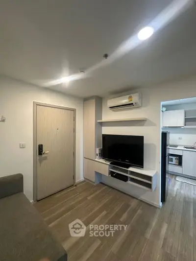 Modern living room with sleek TV setup and open kitchen view