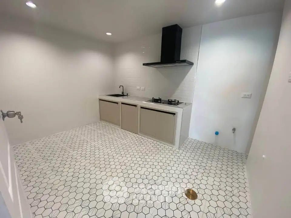 Modern minimalist kitchen with hexagonal tile flooring and sleek cabinetry.