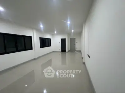 Spacious modern living room with sleek tile flooring and recessed lighting.