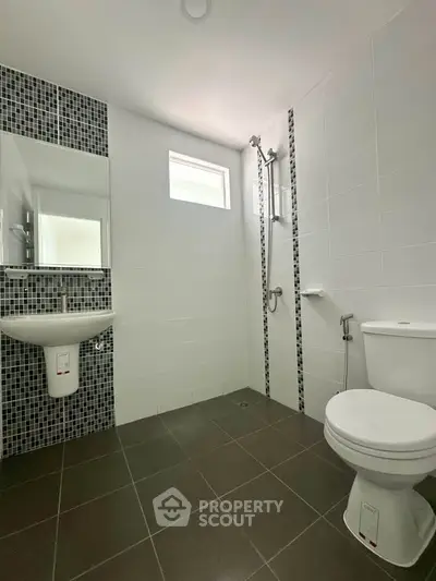 Modern bathroom with sleek tiles and contemporary fixtures in a stylish real estate property.