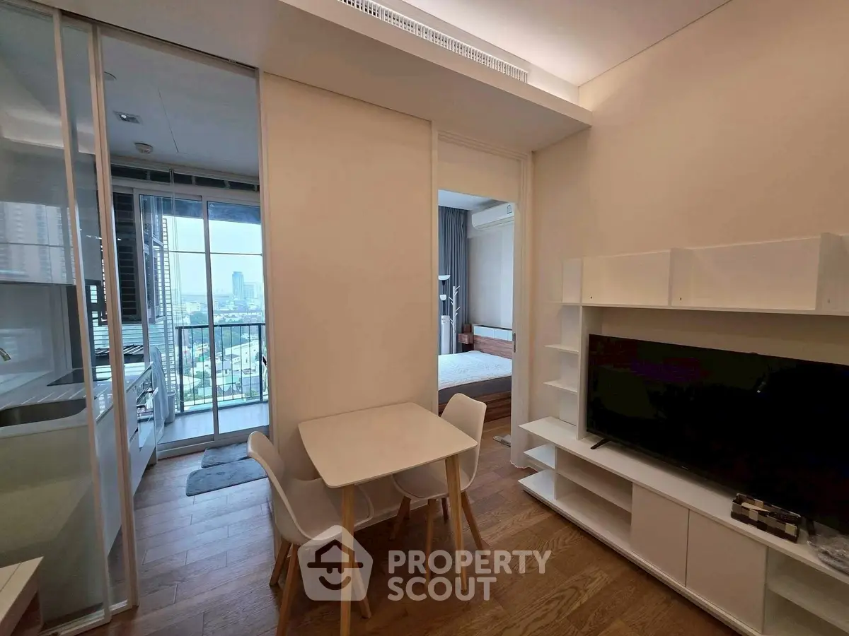 Modern apartment interior with open layout, featuring a cozy dining area and a view of the city skyline.