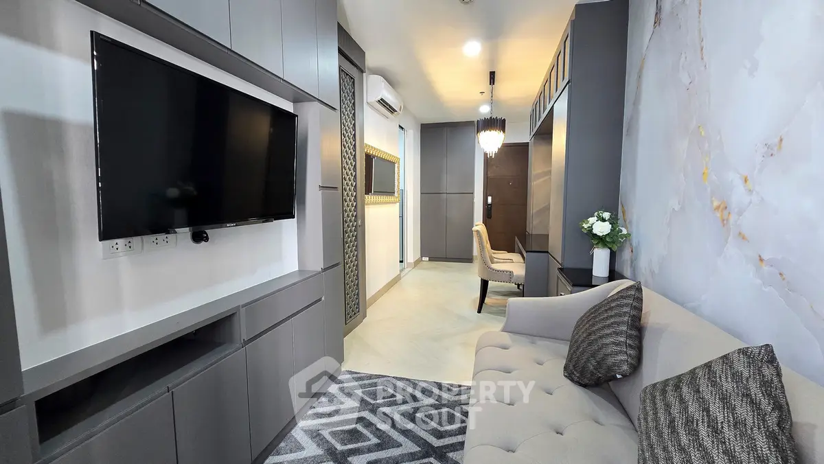 Modern living room with sleek design, featuring a wall-mounted TV, stylish sofa, and elegant decor.
