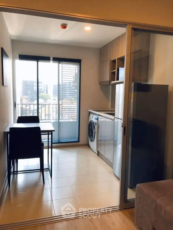 Modern kitchen with washing machine and dining area in a bright apartment