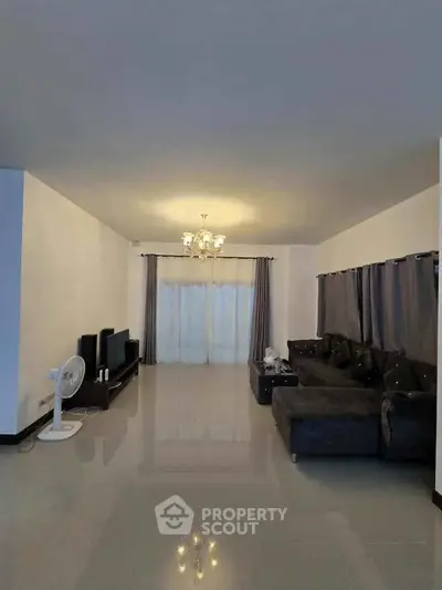 Spacious living room with elegant chandelier and modern furniture