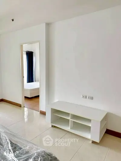 Spacious modern apartment with open layout and sleek white furniture.