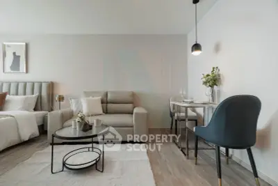 Modern studio apartment with stylish living area and dining space, featuring elegant decor and cozy ambiance.