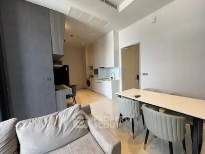 Modern open-plan living and dining area with sleek kitchen and cozy seating.