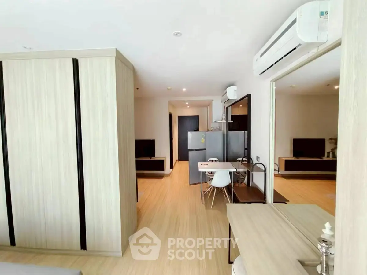Modern open-plan living area with sleek kitchen and dining space, featuring contemporary furniture and neutral tones.