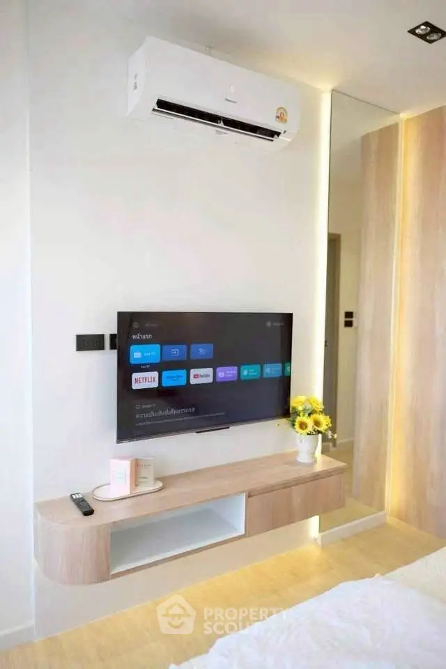 Modern bedroom with wall-mounted TV and air conditioning unit