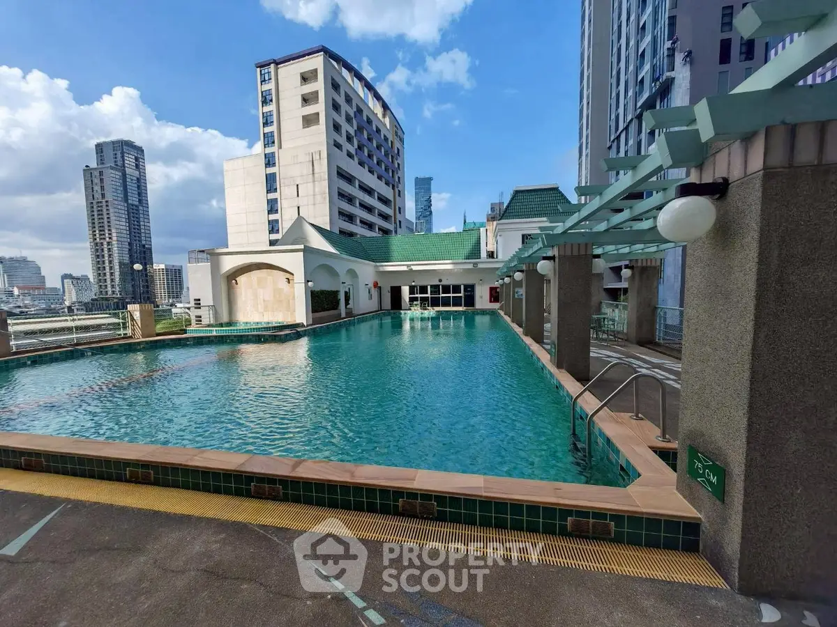 Stunning rooftop pool with city skyline views in modern high-rise building.