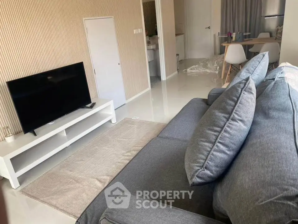 Modern living room with sleek furniture and TV setup, showcasing contemporary interior design.