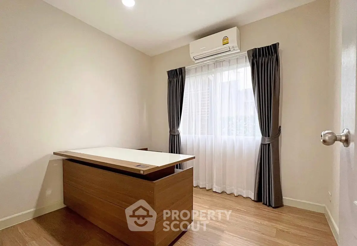 Modern study room with wooden desk and air conditioning, featuring elegant curtains and natural light.