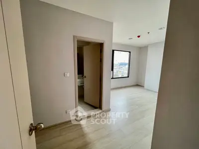 Spacious modern apartment interior with wooden flooring and large window view.