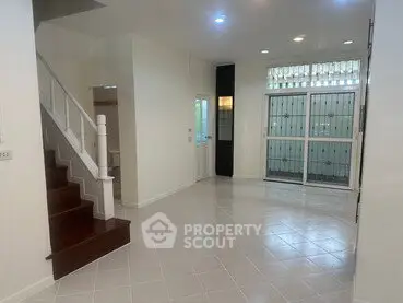 Spacious living room with staircase and large windows in modern home