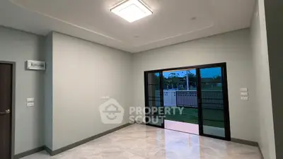 Spacious modern living room with large sliding glass doors opening to a serene garden view.