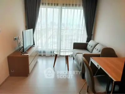 Modern living room with stylish furniture and city view through large window.