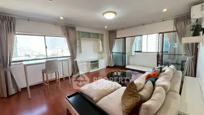 Spacious living room with city view and elegant decor in high-rise apartment.