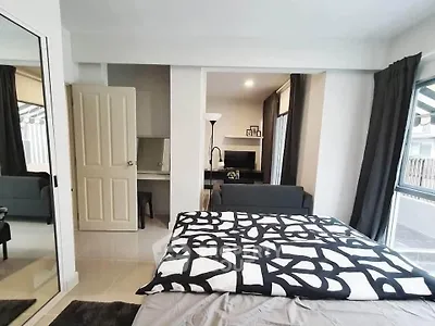 Modern bedroom with stylish decor and open layout leading to a cozy living area.