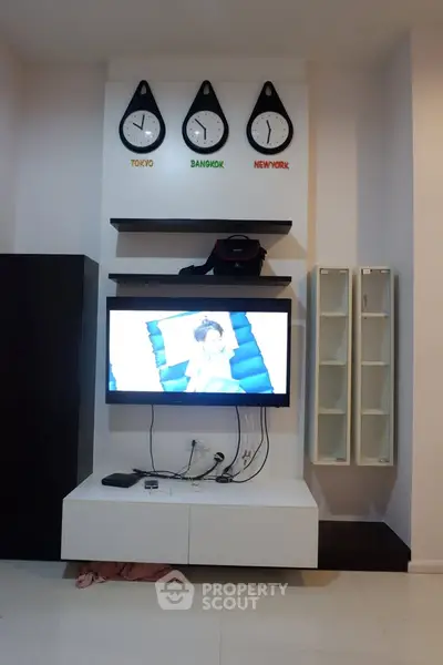 Modern living room with wall-mounted TV and world clocks decor