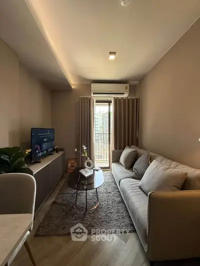 Modern living room with cozy sofa, TV, and balcony view in a stylish apartment.