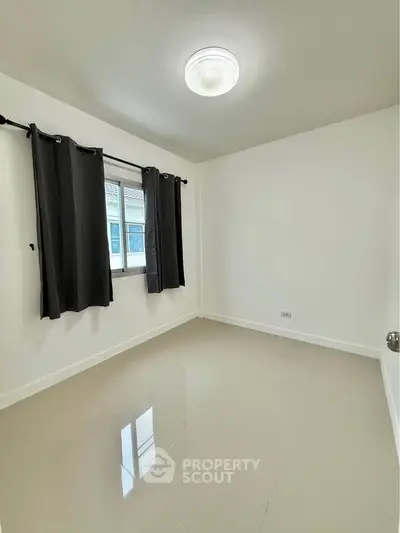 Spacious empty room with glossy tiled floor and window view, perfect for customization.