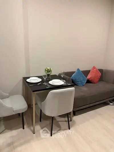 Cozy living room with modern dining set and plush sofa, perfect for urban living.