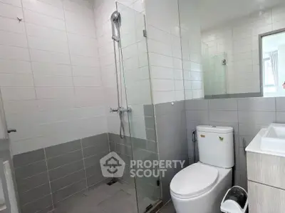 Modern bathroom with glass shower and sleek fixtures in contemporary apartment.
