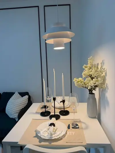 Elegant dining area with modern lighting and stylish table setting in a cozy living space.