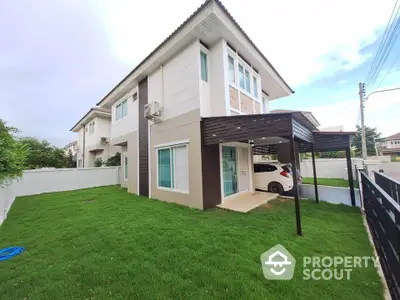 Modern two-story house with carport and lush green lawn in suburban neighborhood